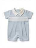 A baby short-sleeve romper in light blue with a white pointed collar and a white smocked chest band, shown flat on a white background.