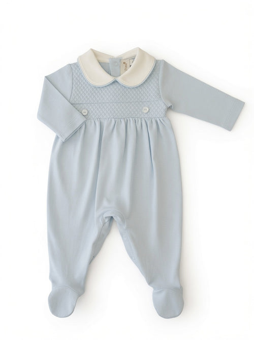 A baby footie in light blu, long sleeves, and a contrasting white-colored Peter Pan collar, laid flat on a white background.