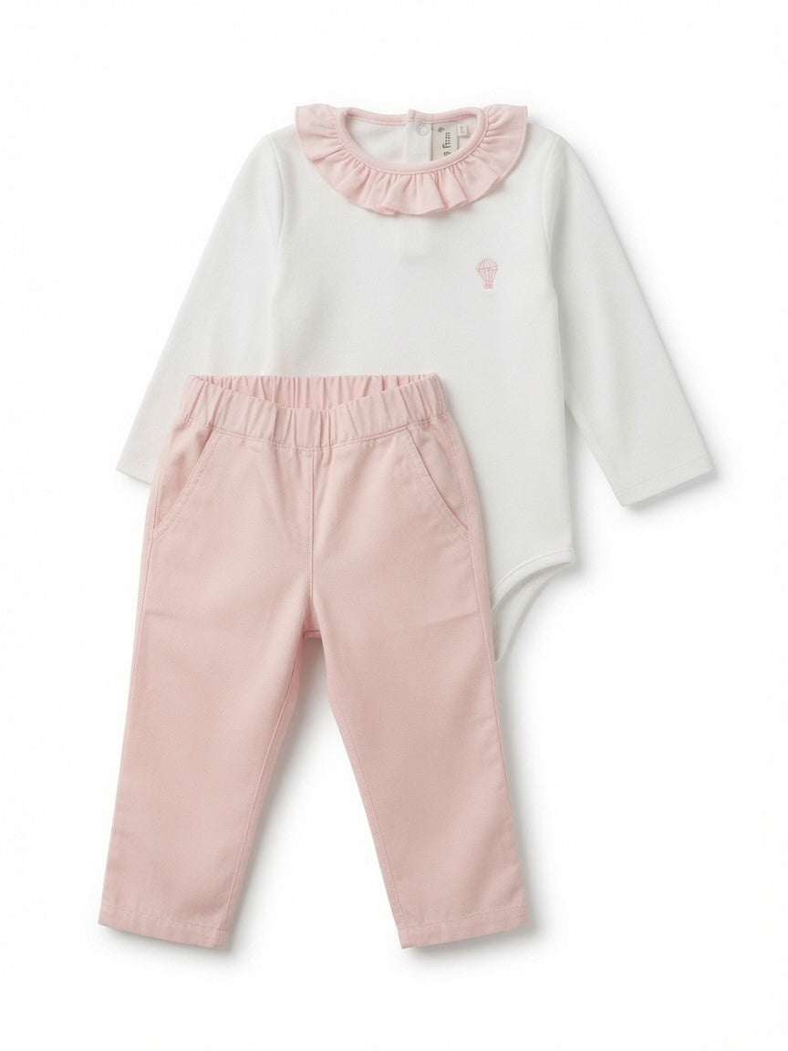 A baby girl's two-piece outfit set featuring a white long-sleeve bodysuit with a pink ruffled collar and a small pink hot air balloon logo, paired with light pink pants.