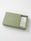 An open sage green gift box with the brand name 'Little Pima' printed in gold on the lid and a card inside, photographed on a clean white background.