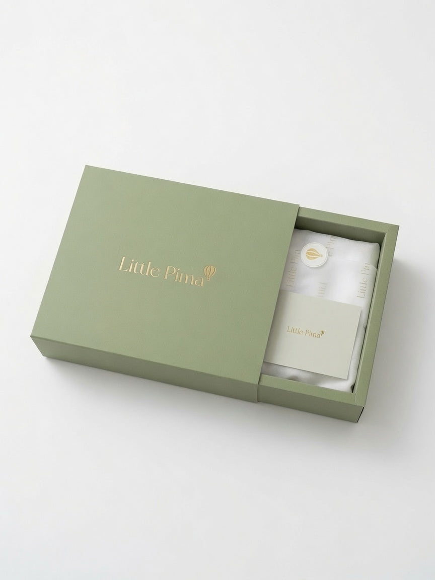 An open sage green gift box with the brand name 'Little Pima' printed in gold on the lid and a card inside, photographed on a clean white background.