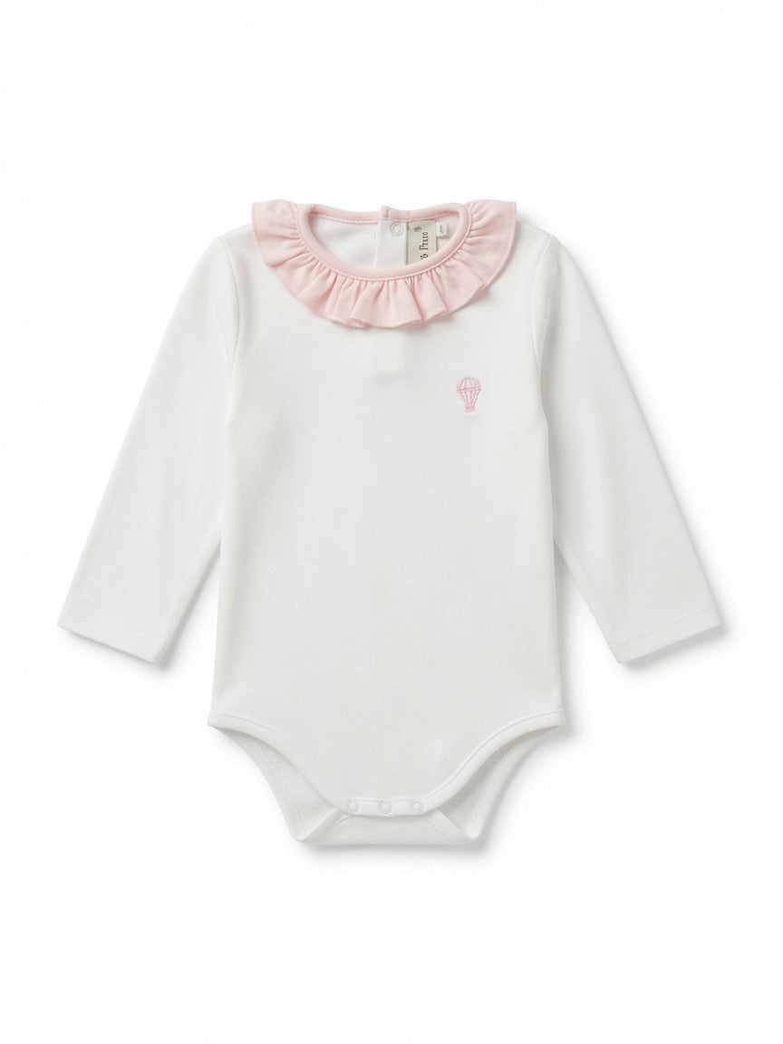 A white long-sleeve baby bodysuit featuring a light pink ruffled collar and a small pink embroidered hot air balloon on the left chest, made from Peruvian pima cotton.