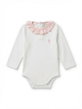 A white long-sleeve baby bodysuit featuring a light pink ruffled collar and a small pink embroidered hot air balloon on the left chest, made from Peruvian pima cotton.
