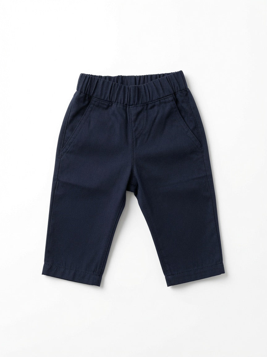 A pair of navy blue pants with an elastic waistband and side pockets, made from Peruvian pima cotton