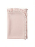 A folded light pink blanket with a decorative ruffled trim along the edge, shown against a plain white background.