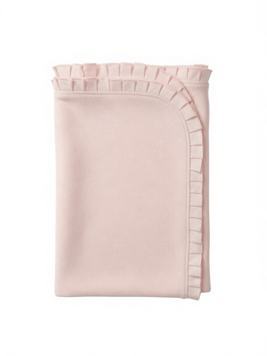 A folded light pink blanket with a decorative ruffled trim along the edge, shown against a plain white background.