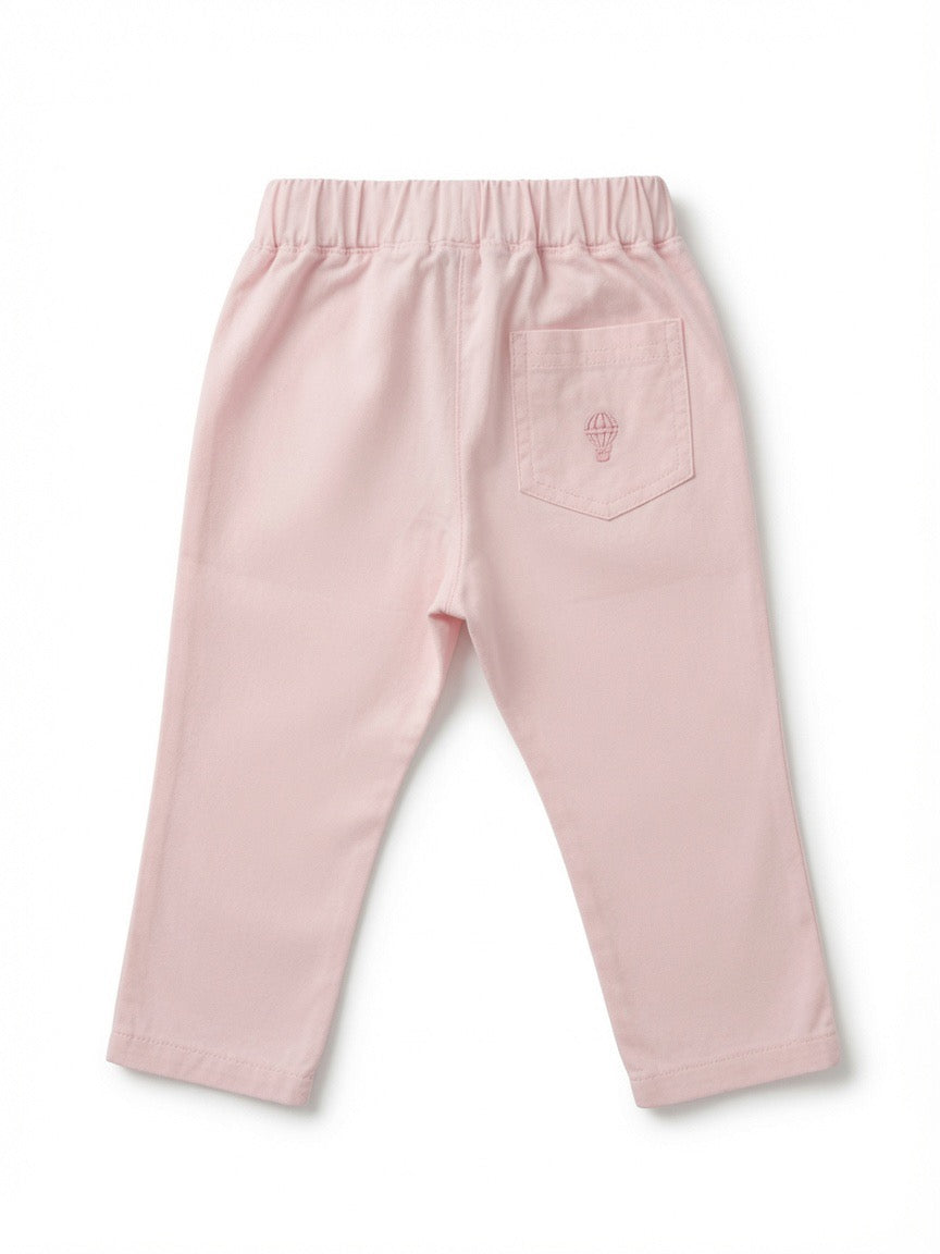 A pair of light pink toddler pants shown from the back, featuring an elastic waistband, side pockets, and a small embroidered hot air balloon logo on the back pocket.