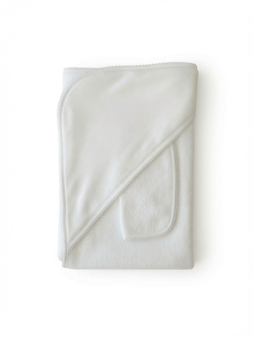 A folded white cotton hooded towel with a diagonal stitched seam and a small pocket on one side, shown on a plain white background.