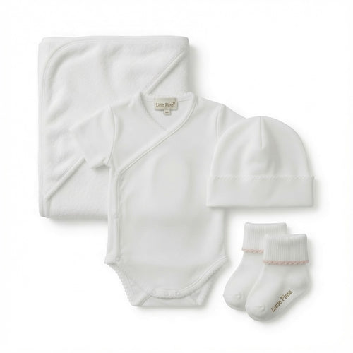 A baby towel set laid out on a white background, including a folded white hooded towel, a white short-sleeve bodysuit, a white beanie hat, and a pair of white socks.